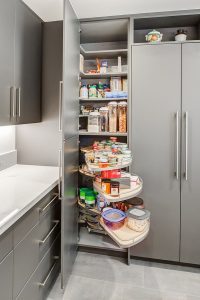 Modern kitchen with integrated storage solutions including custom cabinetry, hidden compartments, and organized drawers