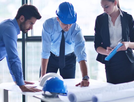 business people group on meeting and presentation  in bright modern office with construction engineer architect and worker looking building model and blueprint planbleprint plans